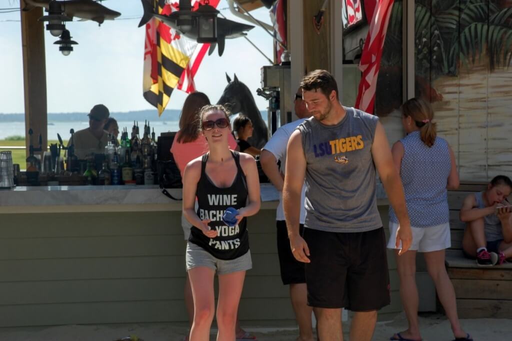 Liz Williams and Sean Duckworth play corn hole and enjoy their drinks in the sun.