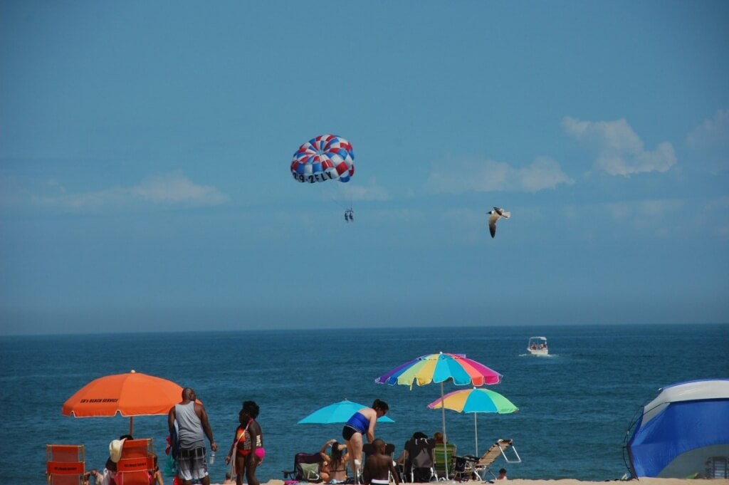 Beachgoers and parasail