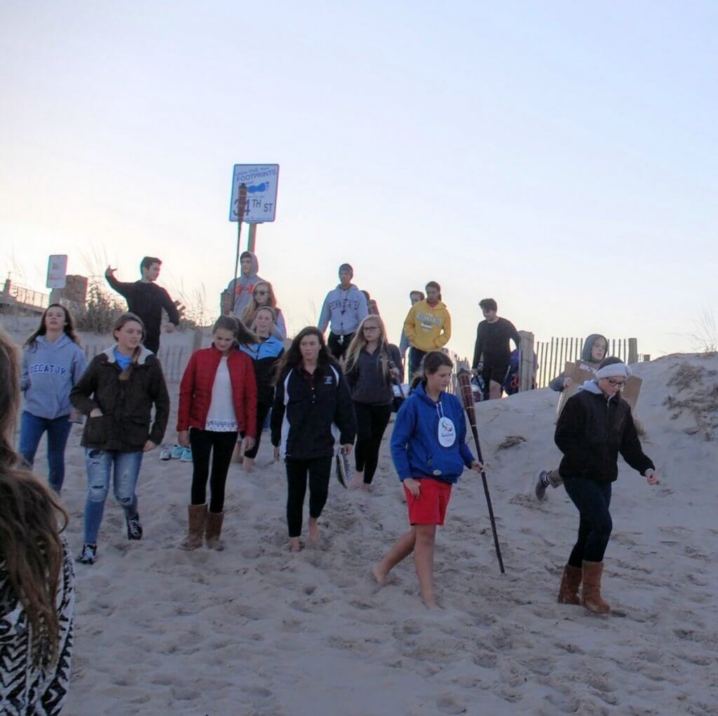 Members of the OCSC and Connections service group descend the dunes on their way to the bonfire following an afternoon of tidying up the beach.