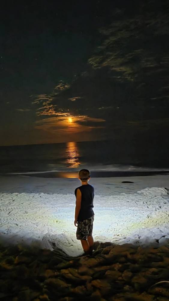 Photo Friday Sheila Mooney My grandson enjoying a night on the beach checking out the ocean and the moon.