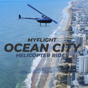 Blue helicopter flying over Ocean City beach and city skyline with promotional text 'MYFLIGHT OCEAN CITY HELICOPTER RIDES'